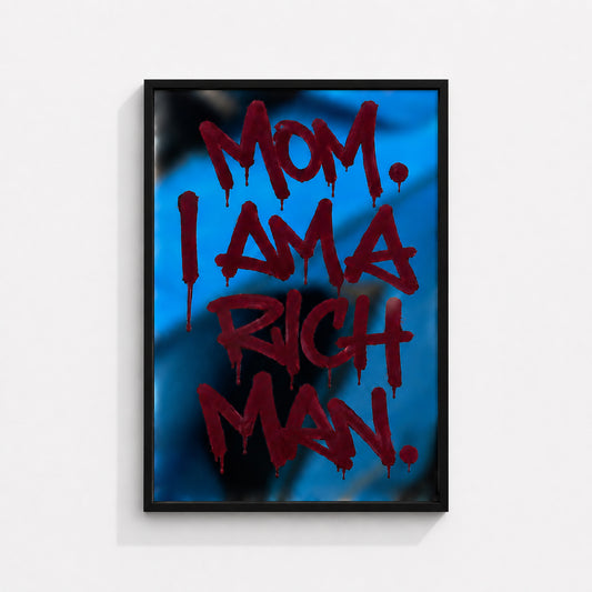MOM. I AM A RICH MAN wall art print in a black box frame featuring bold red typography on a vibrant blue background